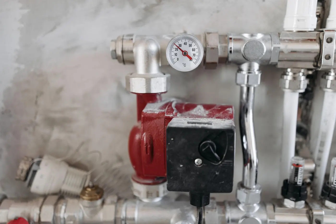 Steel heating pipes and a pressure gauge in a mechanical room