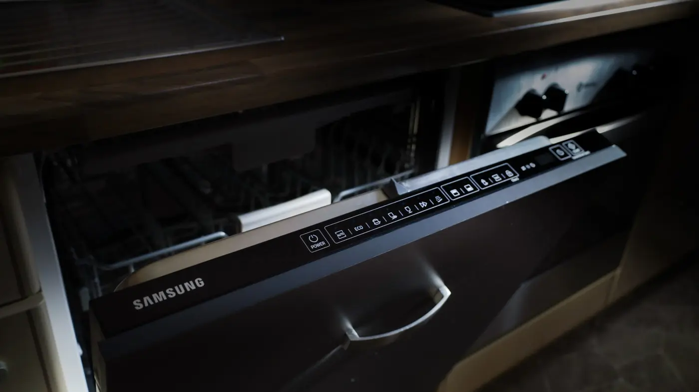 Dishwasher slotted into a kitchen cabinet opening ahead of hookup